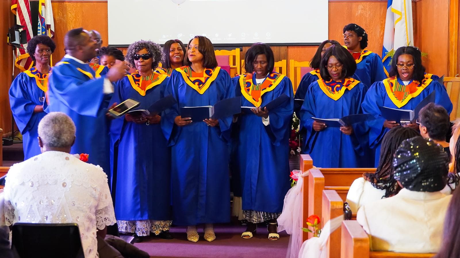 Choir singing in blue robes with vibrant stoles